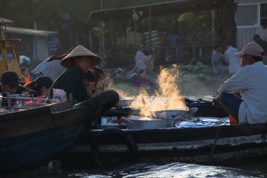 Editorial. Food vendors selling Vietnamese noodle soups in small wooden boats