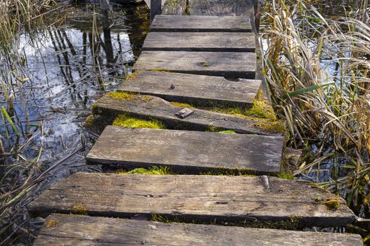 Old rickety rustic wooden jetty on a lake
