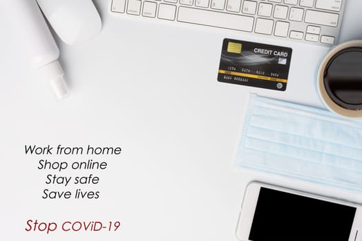 Work from home concept due to Covid-19 or Coronavirus with laptop,antibacterial hand gel, medical mask,hot coffee,credit card and mouse on white background,flat lay