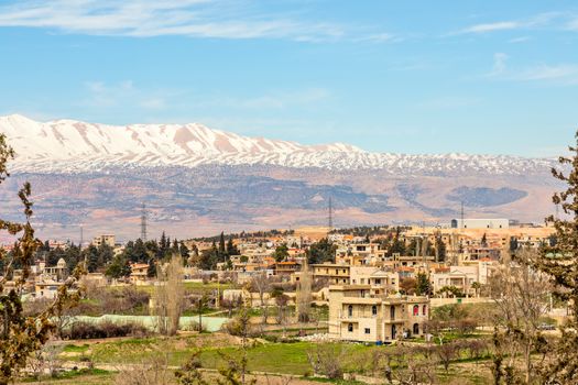 Lebanese houses in Beqaa Valley with snow cap mountains in the b
