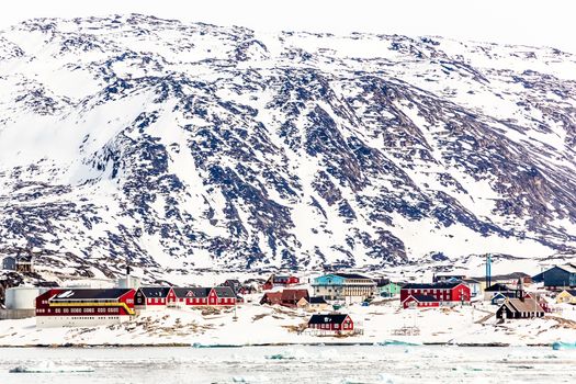 Arctic city panorama with colorful Inuit cottages and oil factor