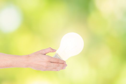 Human hand concept, saving energy from light bulbs, natural boke