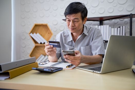 Senior Asian man using smart phone shopping online and paying wi
