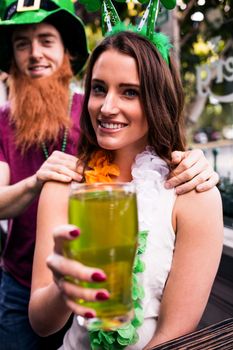 Disguised woman holding a green pint