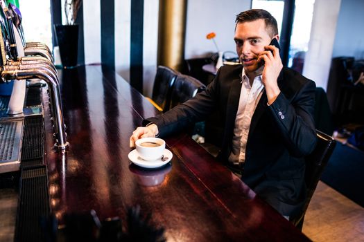 Businessman on the phone having a coffee