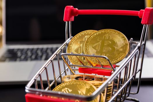 Golden coins with bitcoin symbol in a little shopping cart with 