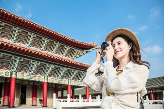 asian female traveler photographing temples at  Asia 