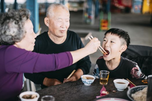 Grandmother feeding her grandson in restaurant