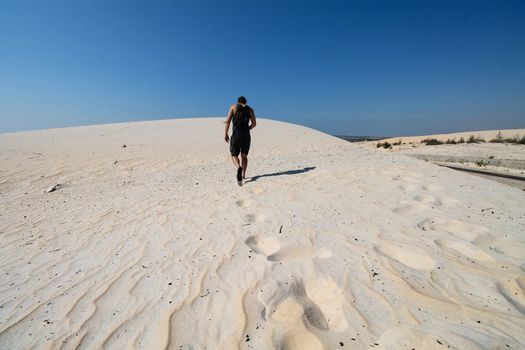 Man Walking in the Desert Sand Dunes