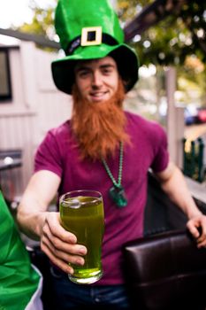 Disguised man holding a green pint 