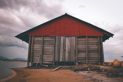Salt storage house against a dark moody sky in the saltfields of Kampot, Cambodia