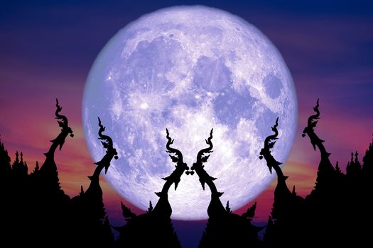blue moon back over silhouette art on roof of Buddhist temple su