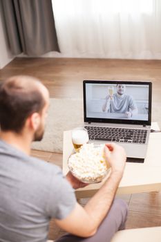 Man eating popcorn during a video call
