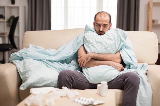 Man with fever wrapped on blanket