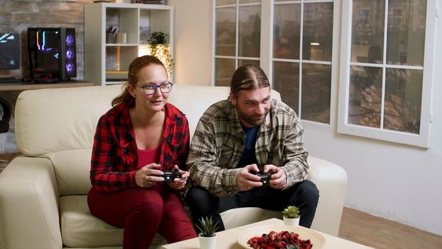 Couple in their 30's relaxing playing video games