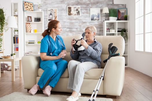 Elderly age woman sitting on couch with nurse