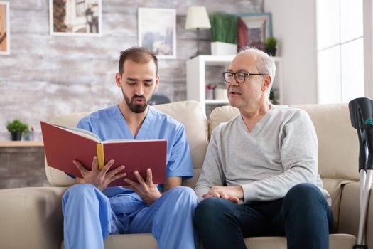 Male doctor reading a book for elderly age male