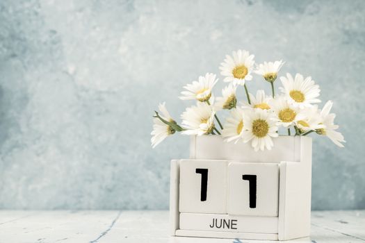 White cube calendar for june decorated with daisy flowers 