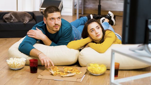 Attractive couple relaxing on pillows for the floor
