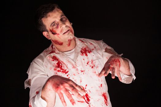 Violent zombie with bloody creative make up over black background