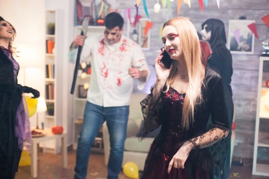 Pretty woman talking on the phone at halloween party