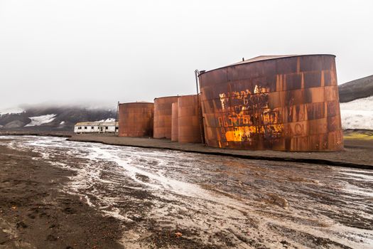 Abandoned norwegian whale hunter station rusty blubber tanks wit