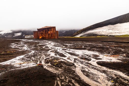 Abandoned norwegian whale hunter station rusty blubber tanks wit