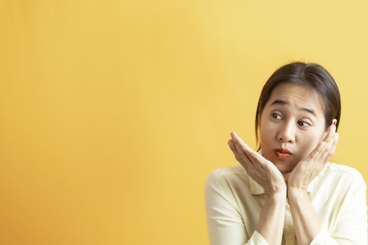 Asian women surprised happy looking sideways in excitement on ye