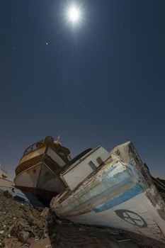Derelict boats in the desert at night