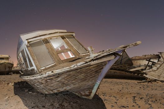 Derelict boats in the desert at night