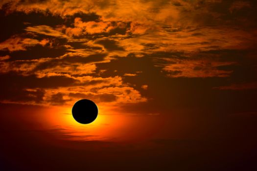 phenomenon of partial sun eclipse over silhouette orange cloud a