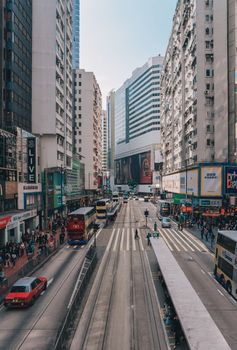 Pedestrians and Bus traffic on a busy street in Central Hong kong, which is a popular travel destination in Hong Kong.