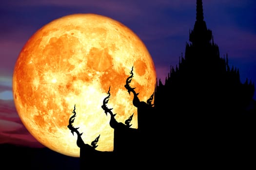 super blood moon back over silhouette art on roof of Buddhist te