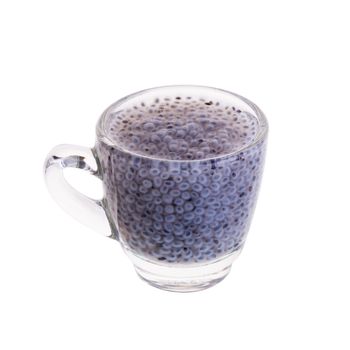 Glass of basil seeds in syrup on a white background