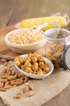 Corn kernels in wooden plates and popcorn with Caramel and almon