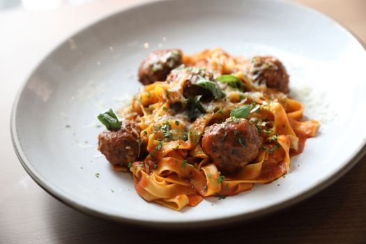 Spaghetti pasta with beef meatballs and tomato sauce on wood bac