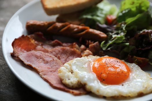 English breakfast  fried egg, ham,sausage, bacon,salad and toast