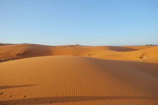 Sand dunes against clear blue sky