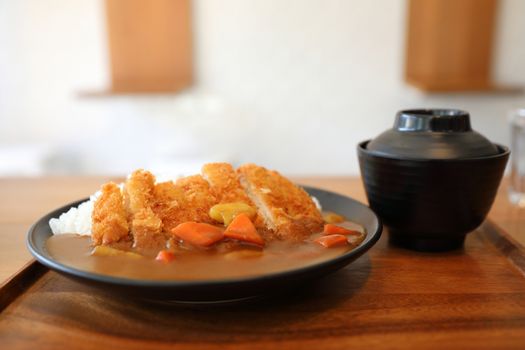 Curry rice with fried pork tonkatsu Japanese food on wooden tabl