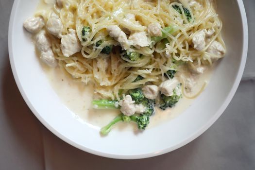 alfredo spaghetti broccoli chicken white sauce in restaurant bac