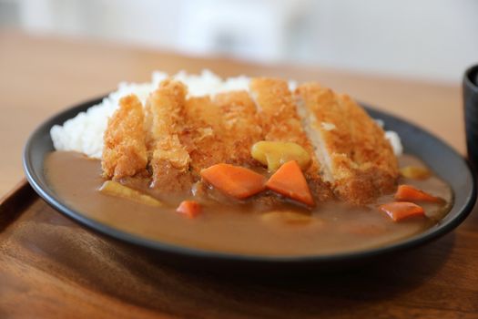 Curry rice with fried pork tonkatsu Japanese food on wooden tabl