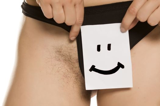 Young woman showing her pubic hair with smile on paper