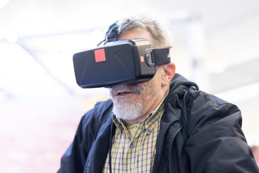Senior man wearing virtual reality headset glasses. Virtual reality presentation