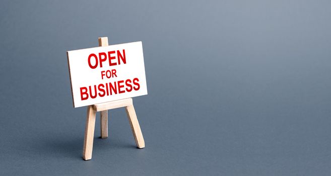 Open for business easel sign. Opening a business of establishments, resuming economic life after a long closure. Economy recovery from the crisis. Financial support, preferential cheap loans.