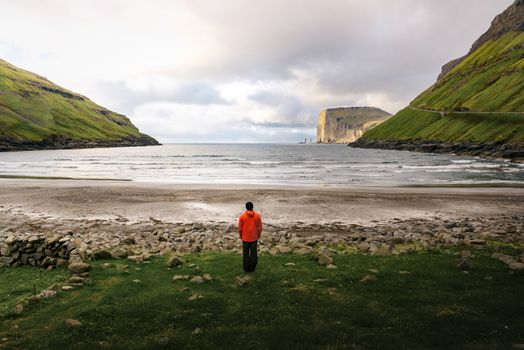 Tourist standing at the beach in Tjornuvik in the Faroe Islands, Denmark