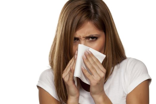 young beautiful woman sneeze in a tissue