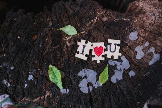A picture of a paper jigsaw put on a tree stump and write that I