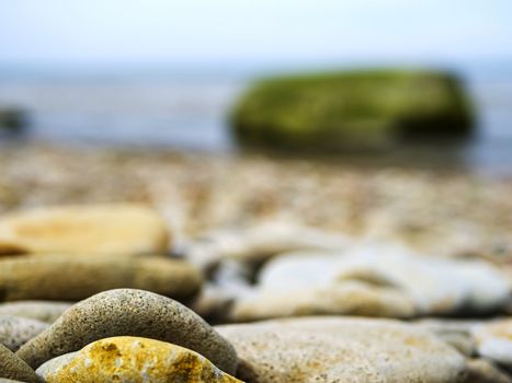 Selective focus. Coast. Spa stones, sea beach. Coast. many Stones on the beach and sea water in sunset light.