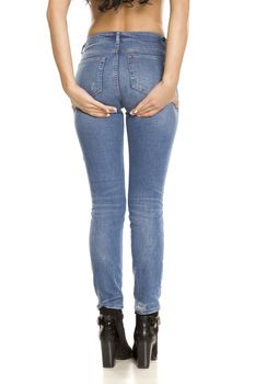 Woman in jeans lifting her ass with her hands