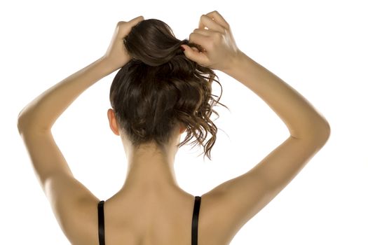 woman from behind,  tying her hair